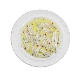 Photo of Tasty pickled anchovies with spices isolated on white, top view