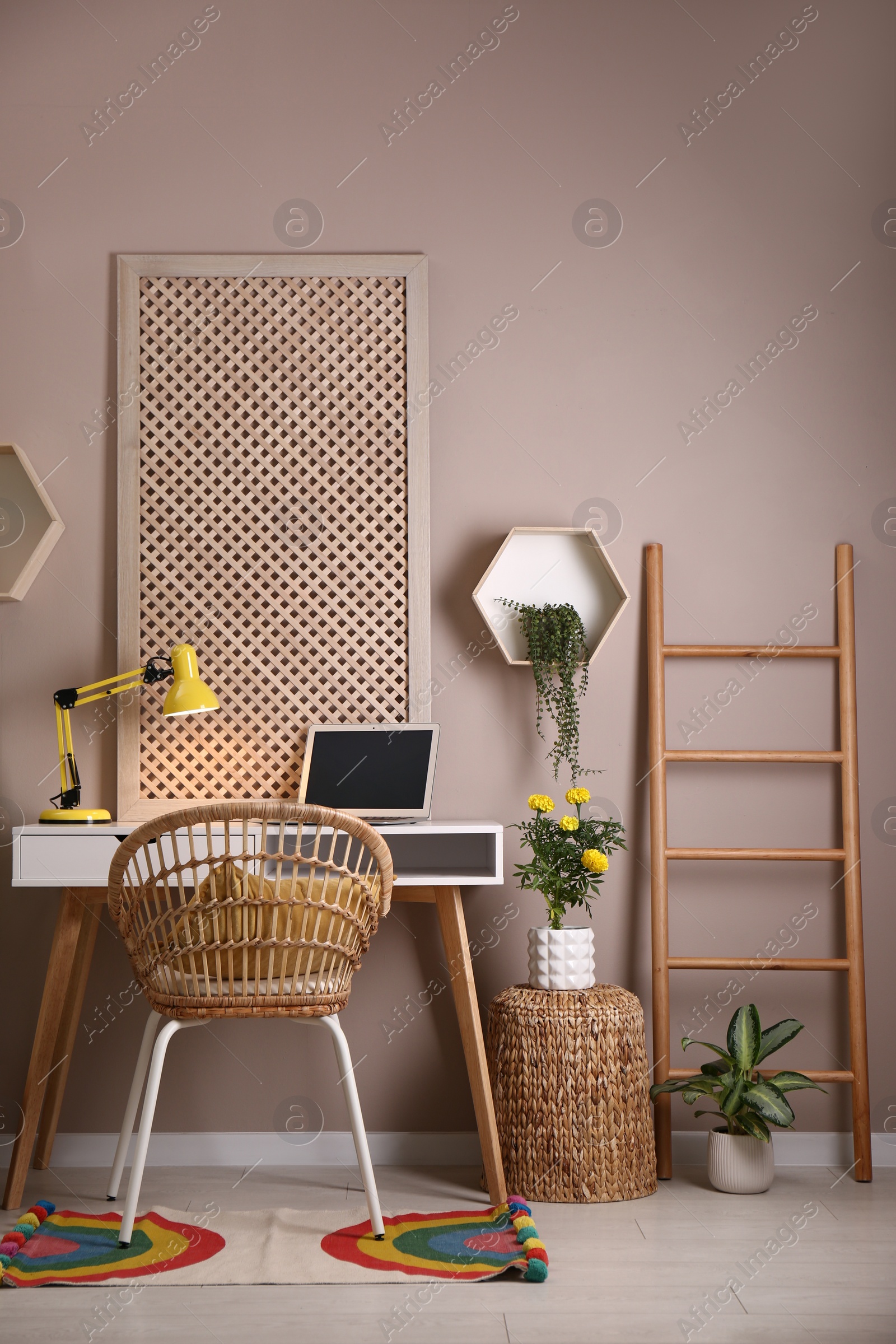 Photo of Comfortable workplace with modern laptop and houseplants in room. Interior design