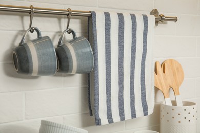 Kitchen towel and cups hanging on rack indoors