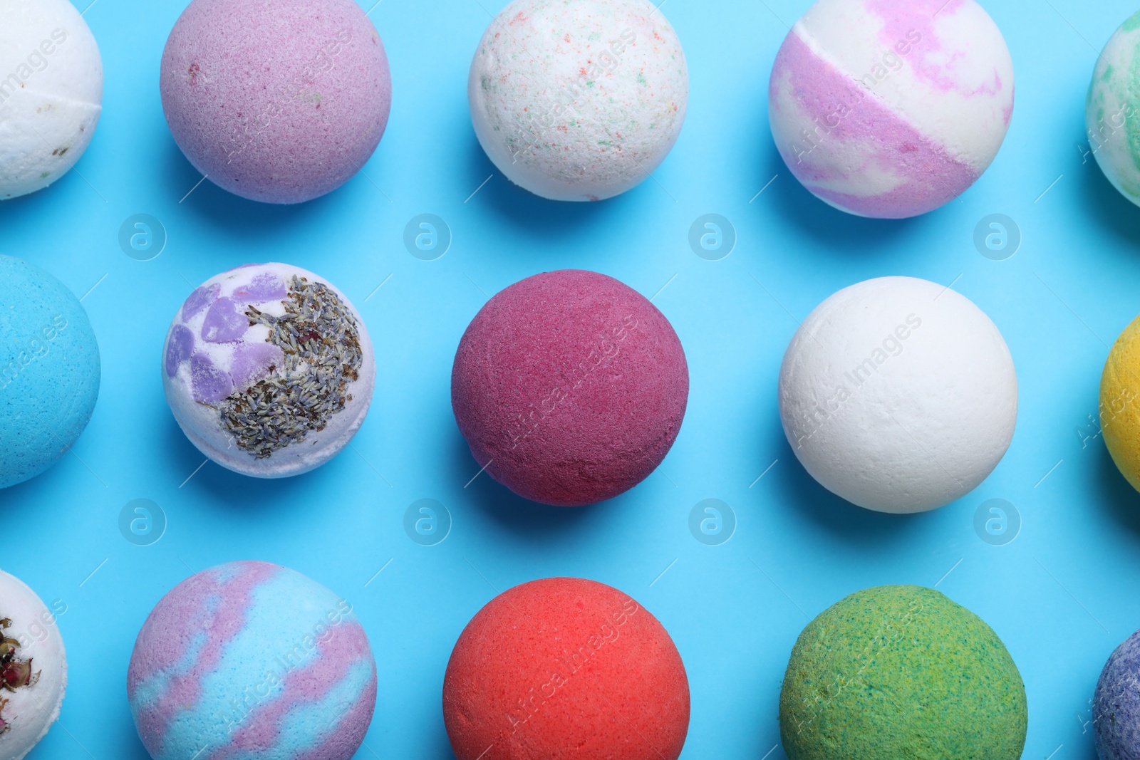 Photo of Colorful bath bombs on light blue background, flat lay