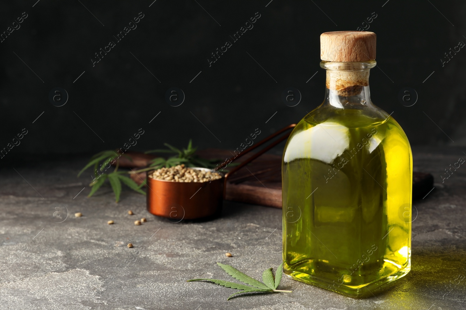 Photo of Bottle of hemp oil on grey stone table