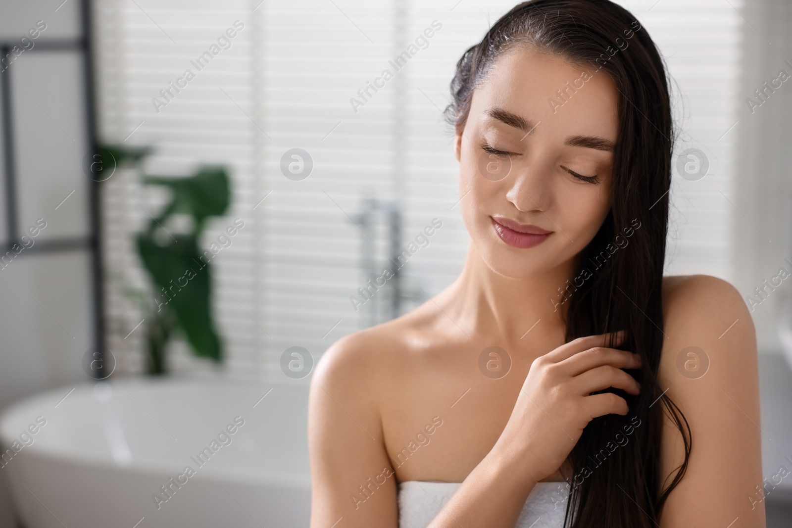 Photo of Beautiful young woman after shower in bathroom. Space for text