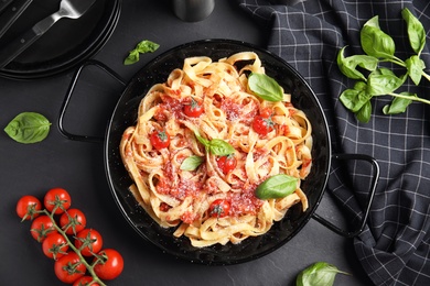 Flat lay composition with tasty pasta on black table