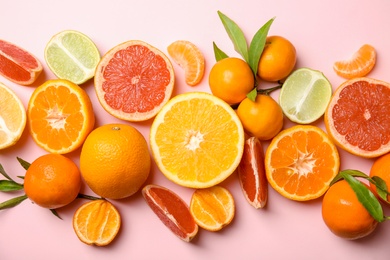 Different citrus fruits on color background, top view