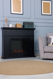 Black stylish fireplace with books and accessories in cosy living room