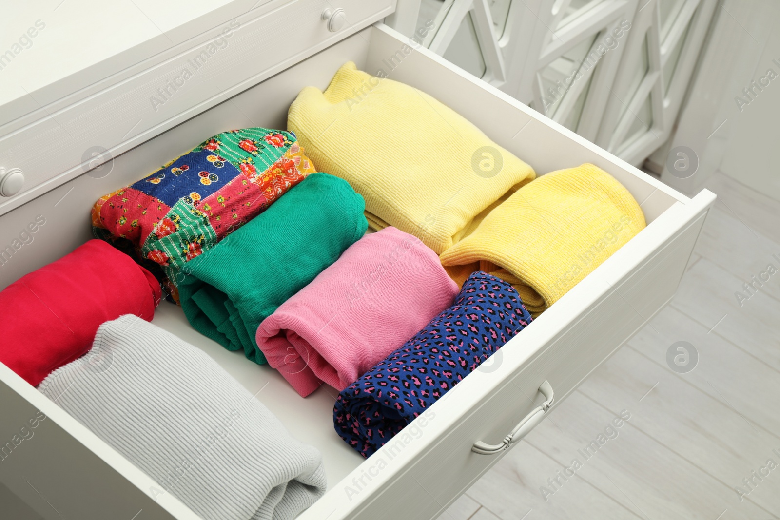 Photo of Folded clothes in open drawer. Apparel storage