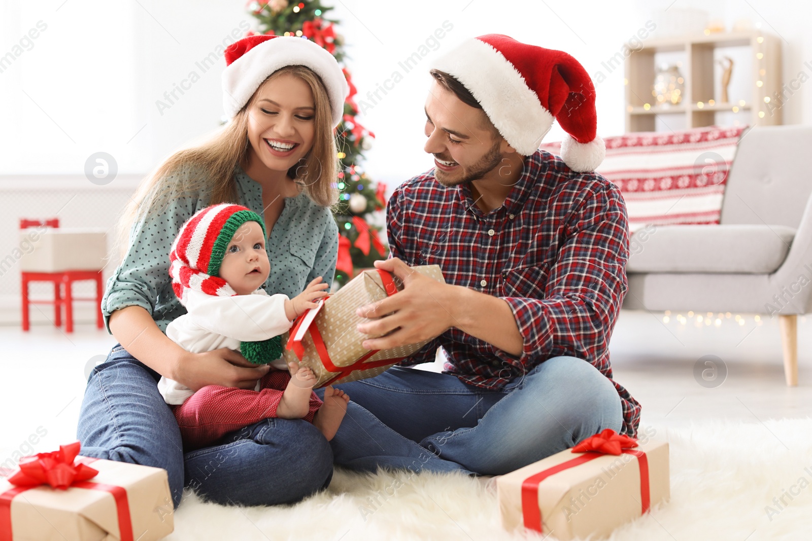 Photo of Happy couple with baby celebrating Christmas together at home