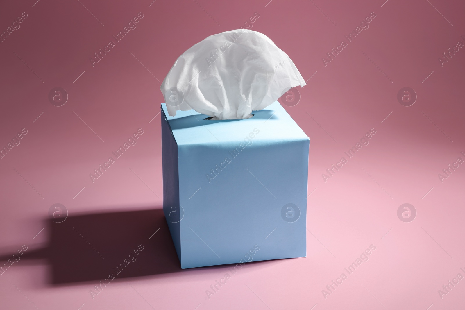 Photo of Box with paper tissues on pink background