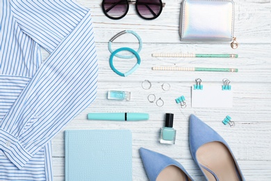 Photo of Flat lay composition with clothes, cosmetics and stylish accessories on light background