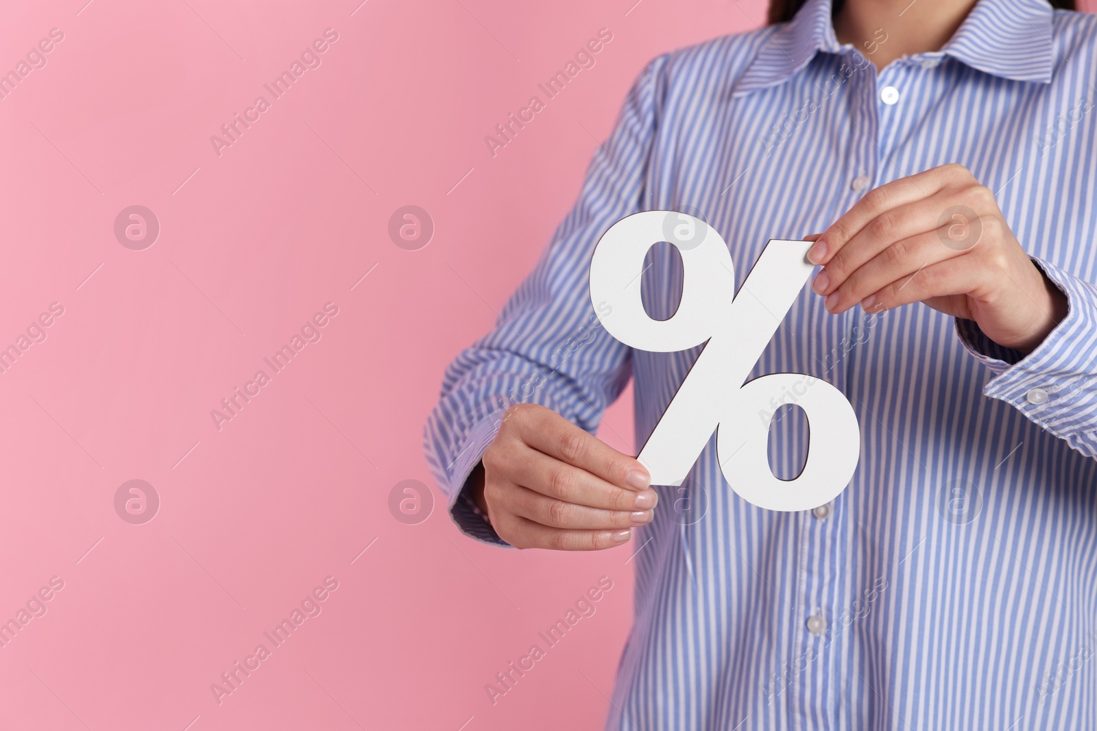 Photo of Woman holding percent sign on pink background, closeup. Space for text