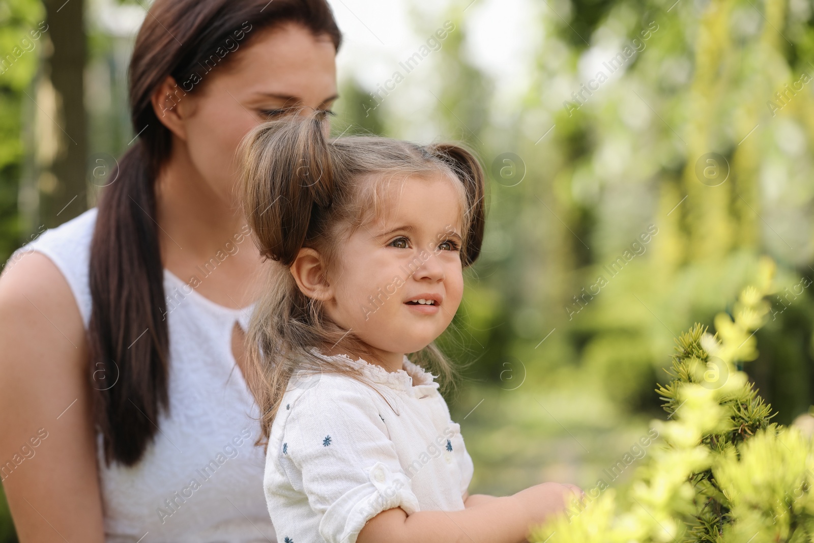 Photo of Mother with her cute daughter spending time together outdoors, space for text