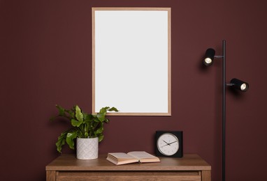 Blank frame hanging on dark wall indoors. Space for design