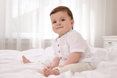 Cute baby boy on bed at home