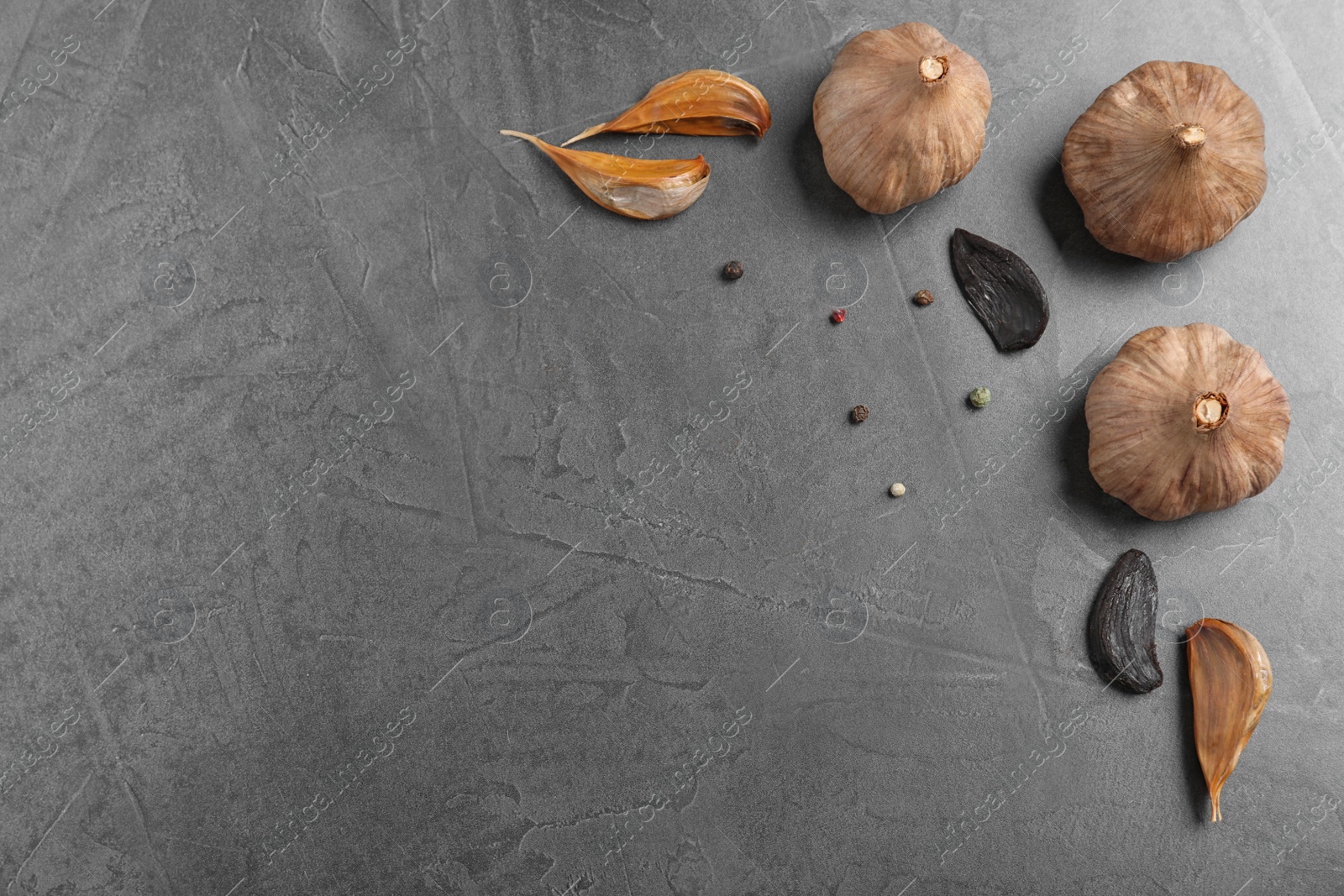 Photo of Flat lay composition with black garlic and space for text on grey background