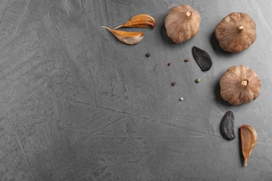 Flat lay composition with black garlic and space for text on grey background