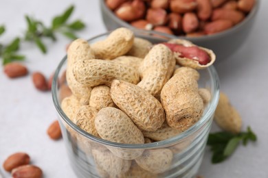 Fresh unpeeled peanuts on grey table, closeup