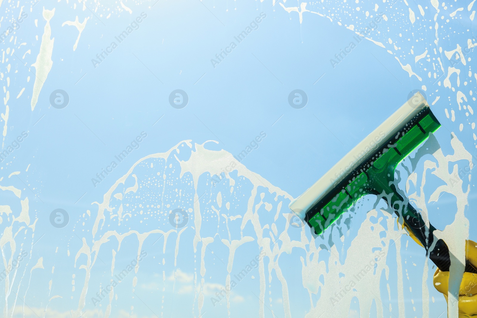 Photo of Person cleaning glass with squeegee , view from inside