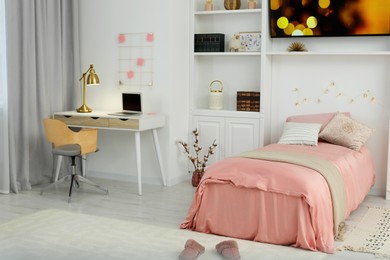 Stylish teenager's room interior with comfortable bed, workplace and modern TV set