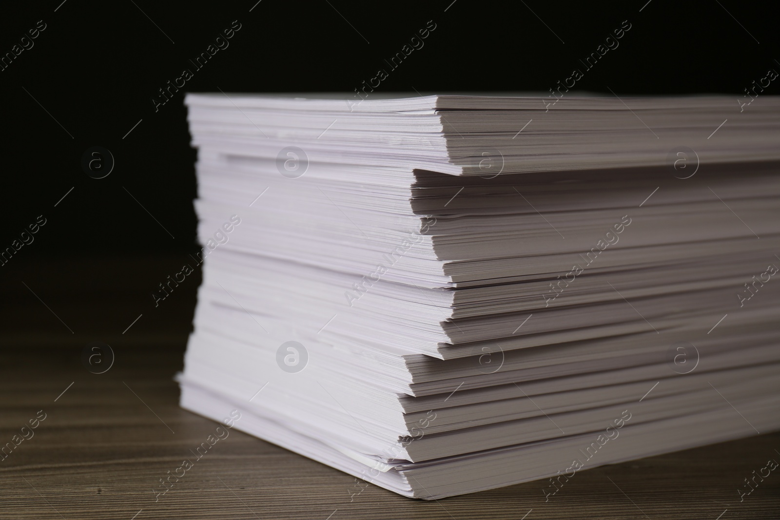 Photo of Stack of paper sheets on wooden table, closeup