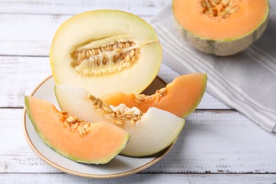 Photo of Tasty colorful ripe melons on white wooden table