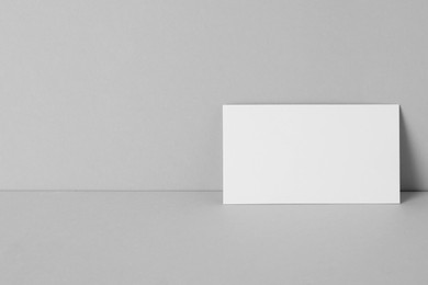 Blank business card on light grey background. Mockup for design