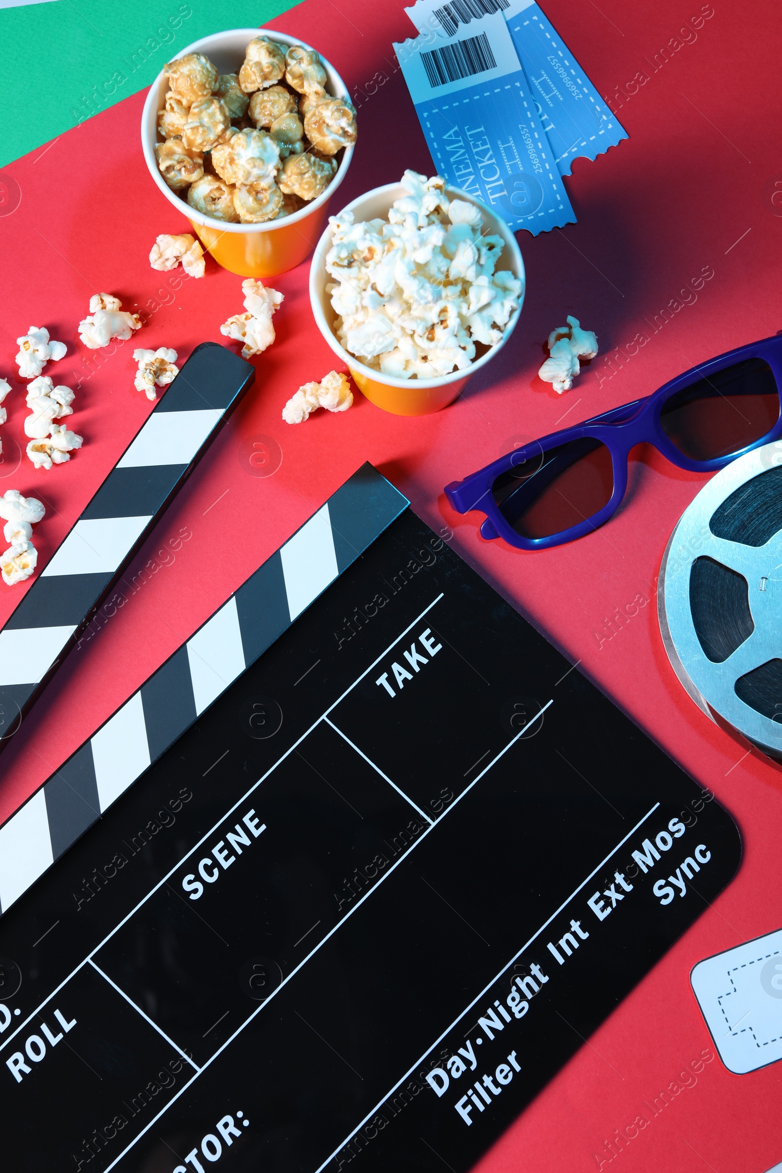 Photo of Flat lay composition with clapperboard and popcorn on color background