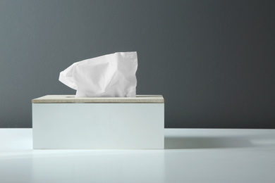 Photo of Holder with paper tissues on white table. Space for text