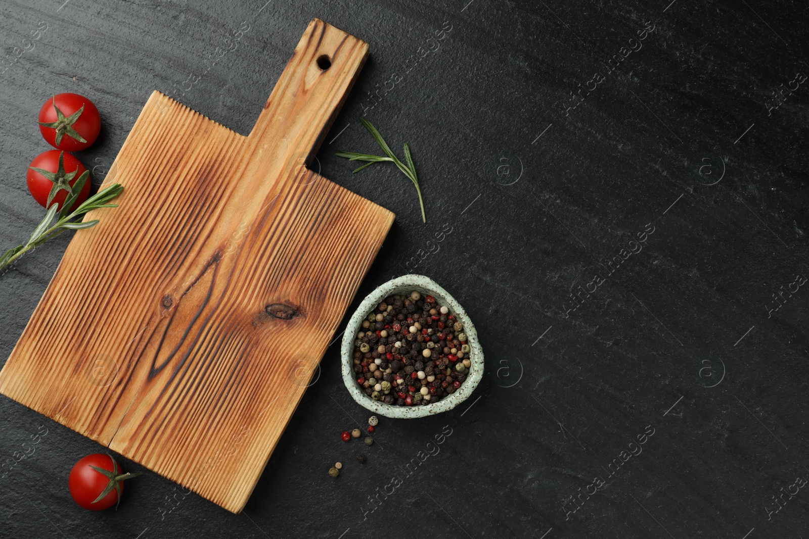 Photo of Wooden cutting board, fresh tomatoes and different spices on grey textured table, flat lay. Space for text