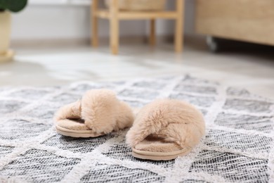 Photo of Beige soft slippers on carpet indoors, closeup