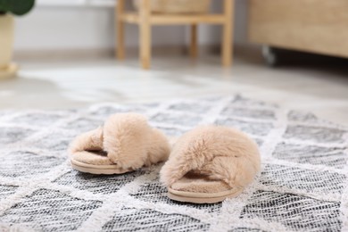 Beige soft slippers on carpet indoors, closeup