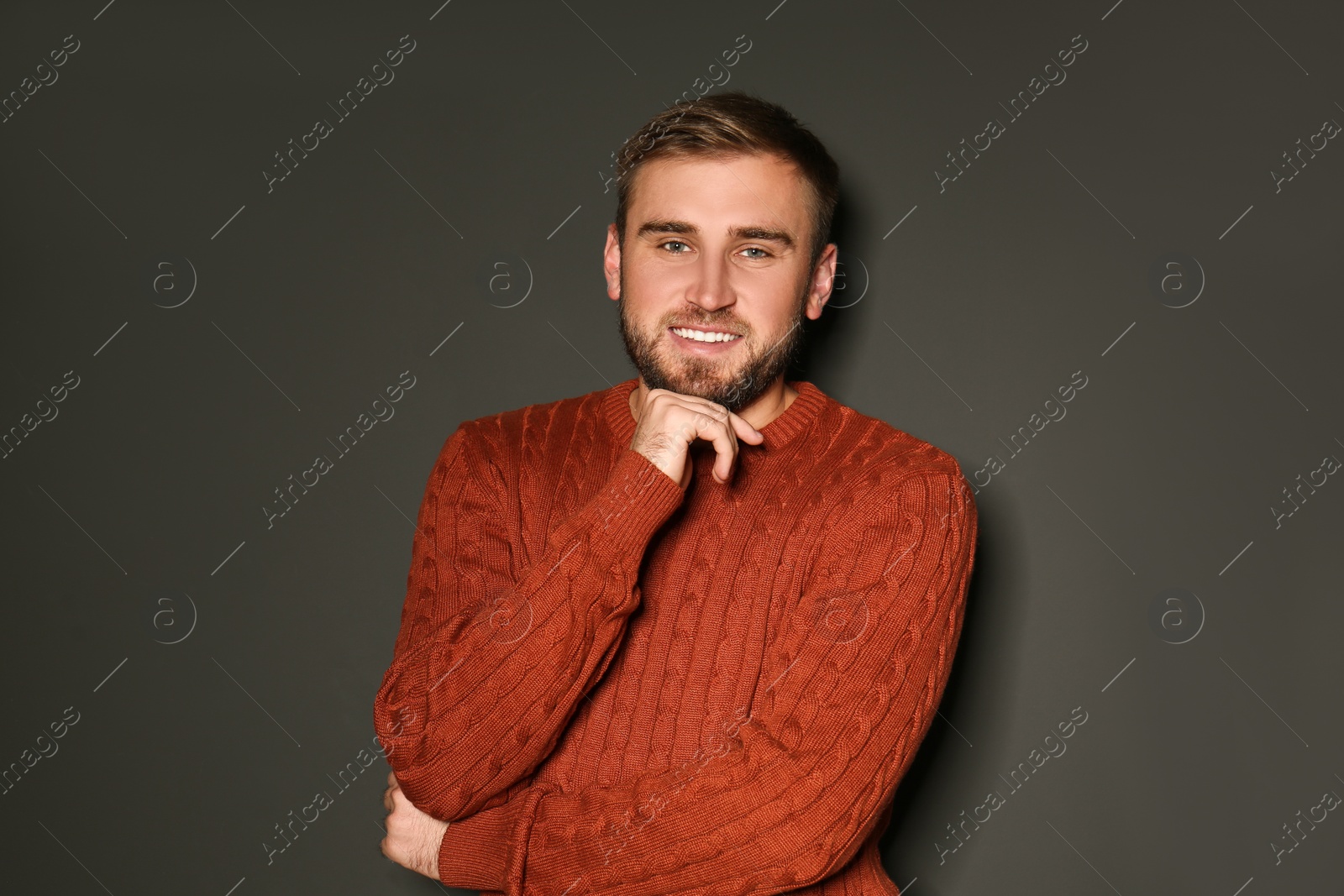 Image of Handsome man wearing warm sweater on dark background 