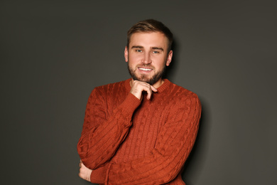 Handsome man wearing warm sweater on dark background 