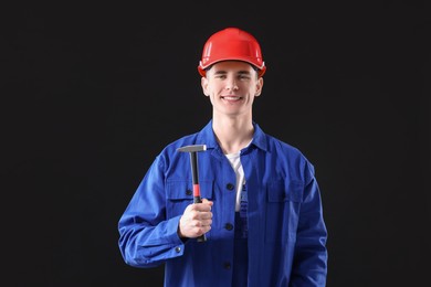 Photo of Professional repairman holding hammer on black background