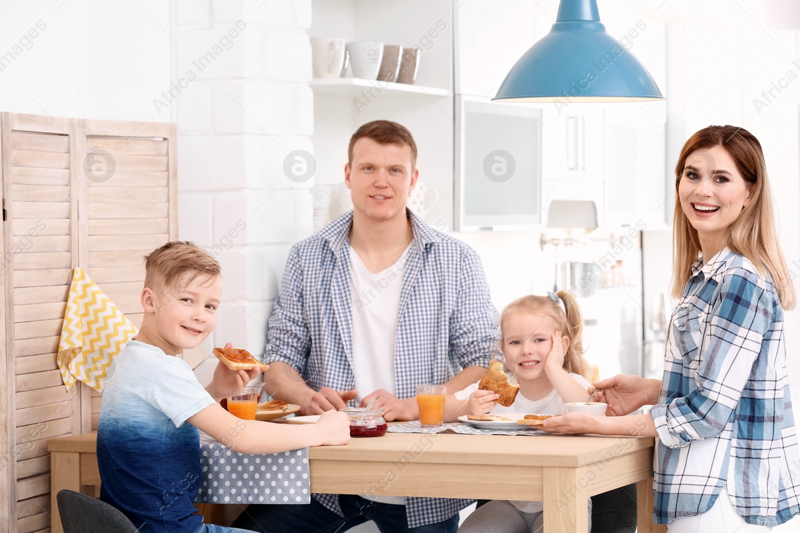 Photo of Parents and cute little children having breakfast with tasty toasted bread at table