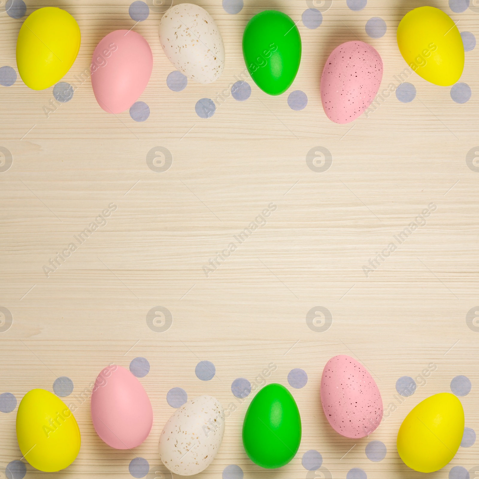 Image of Many decorated Easter eggs and confetti on wooden table, flat lay. Space for text