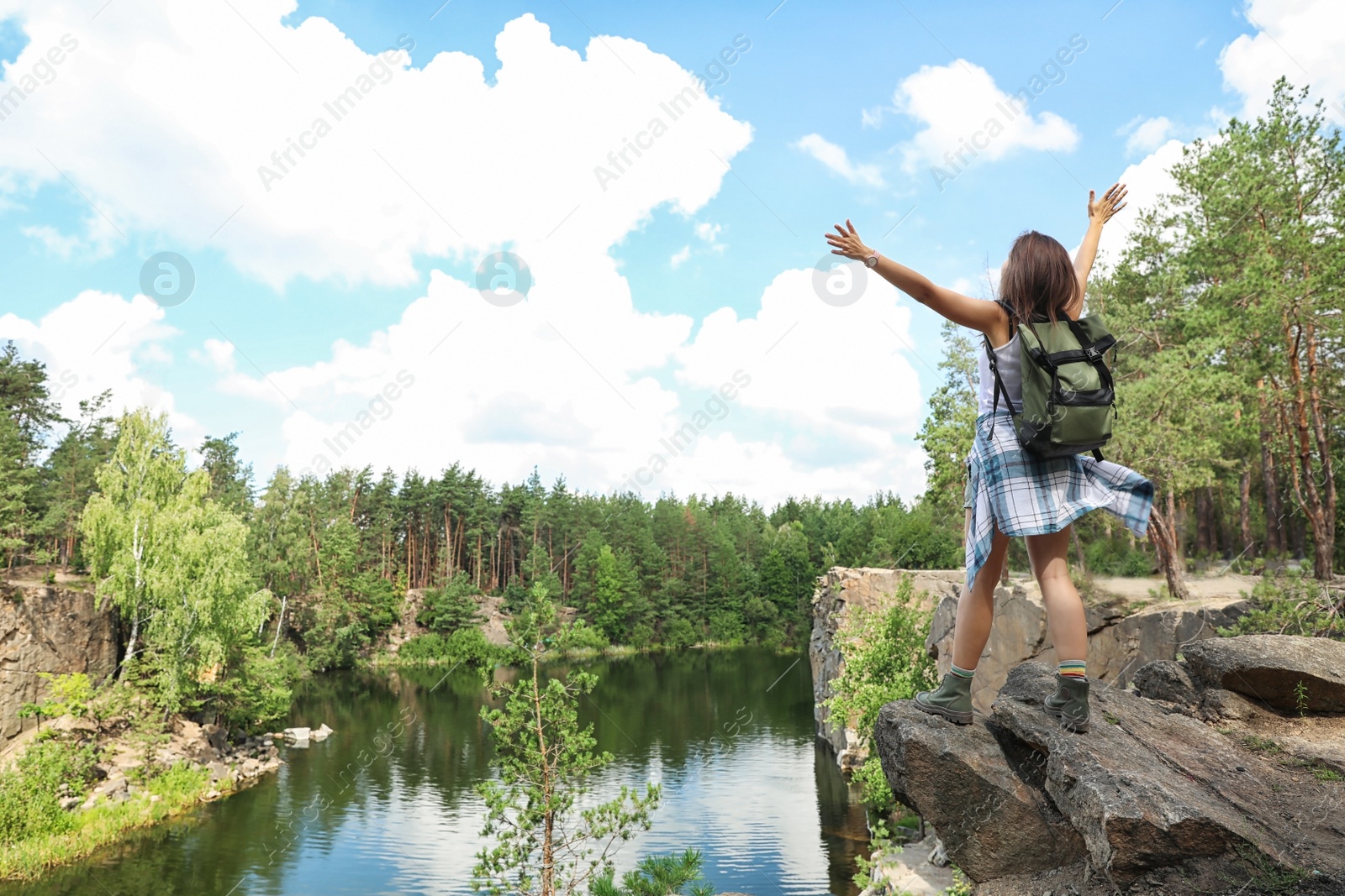 Photo of Young woman on rocky mountain in forest. Camping season