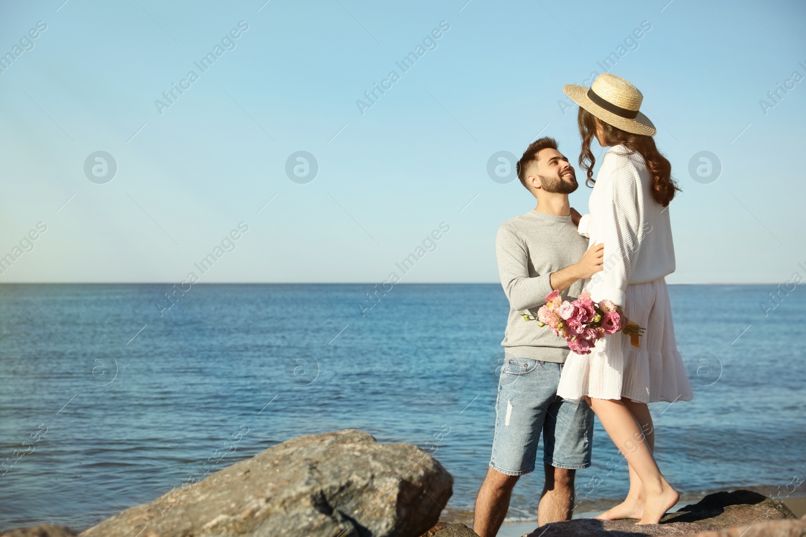 Photo of Happy young couple on beach near sea. Honeymoon trip