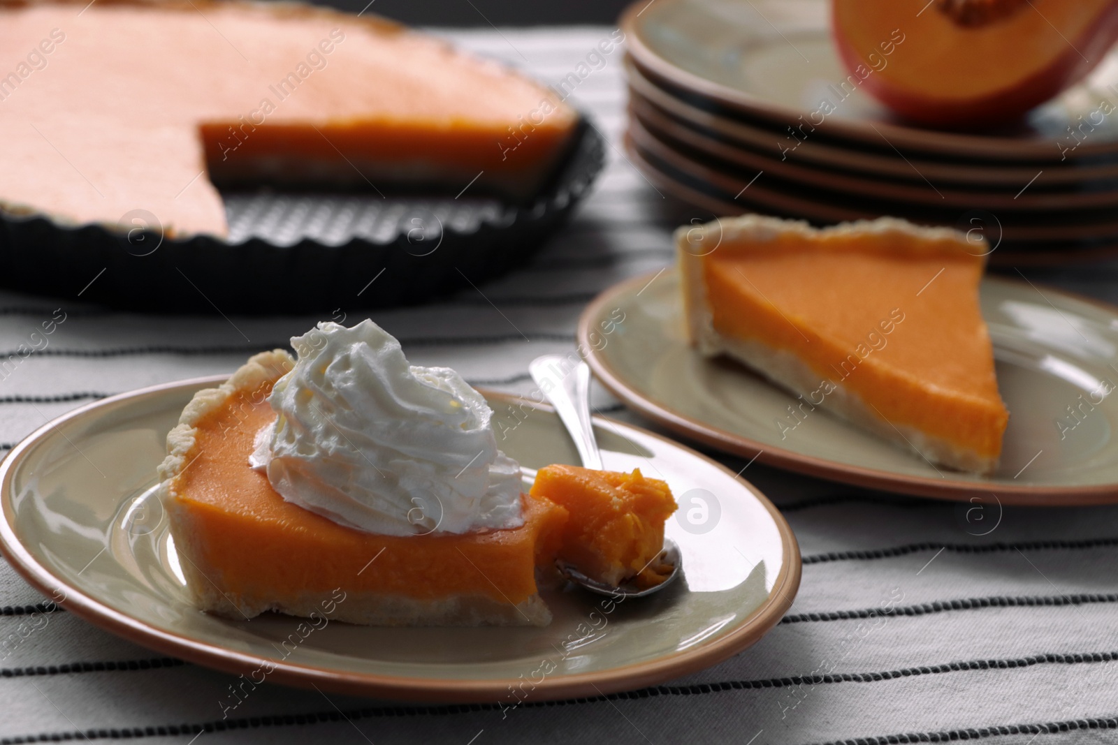 Photo of Fresh homemade pumpkin pie with whipped cream on table