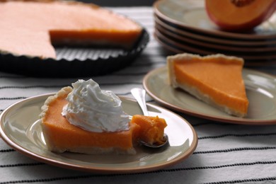 Photo of Fresh homemade pumpkin pie with whipped cream on table