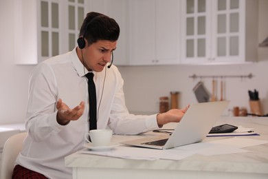 Photo of Man working on laptop in kitchen. Stay at home concept