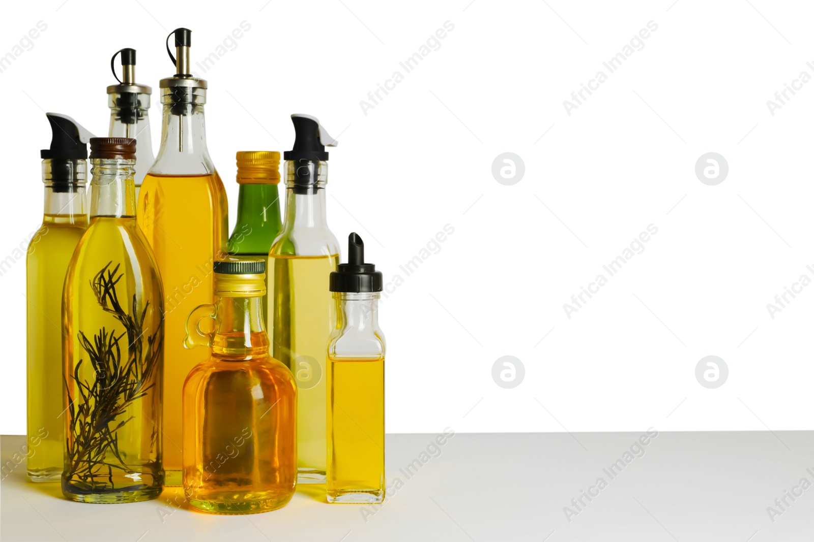 Photo of Bottles of different cooking oils on white background, space for text