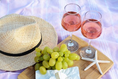 Photo of Glasses with rose wine and snacks on picnic blanket