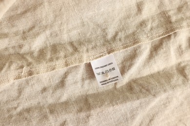 Photo of Clothing label on beige garment, closeup view