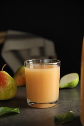 Fresh pear juice in glass on grey table