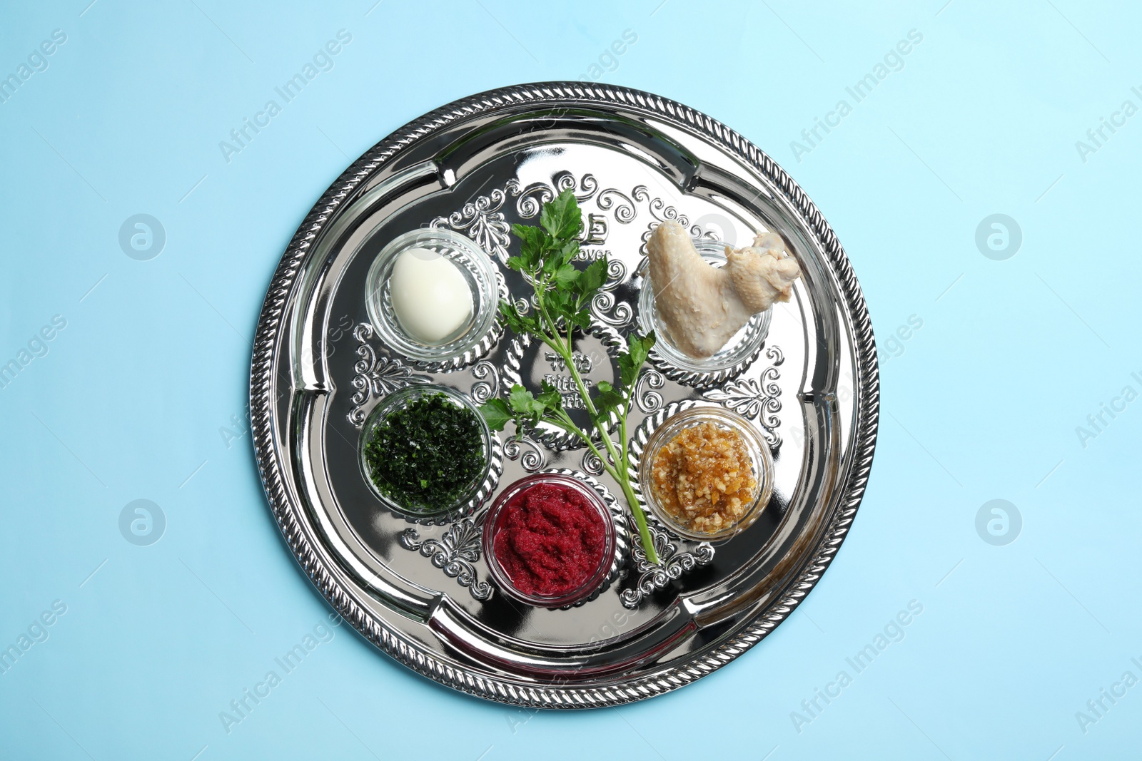 Photo of Traditional silver plate with symbolic meal for Passover (Pesach) Seder on color background, top view