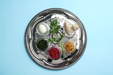 Traditional silver plate with symbolic meal for Passover (Pesach) Seder on color background, top view