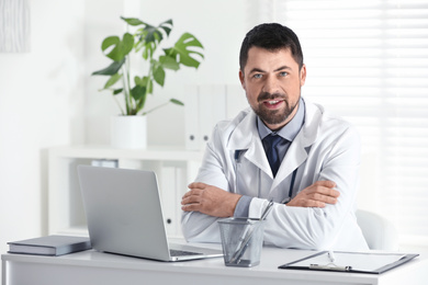 Photo of Portrait of male doctor in white coat at workplace