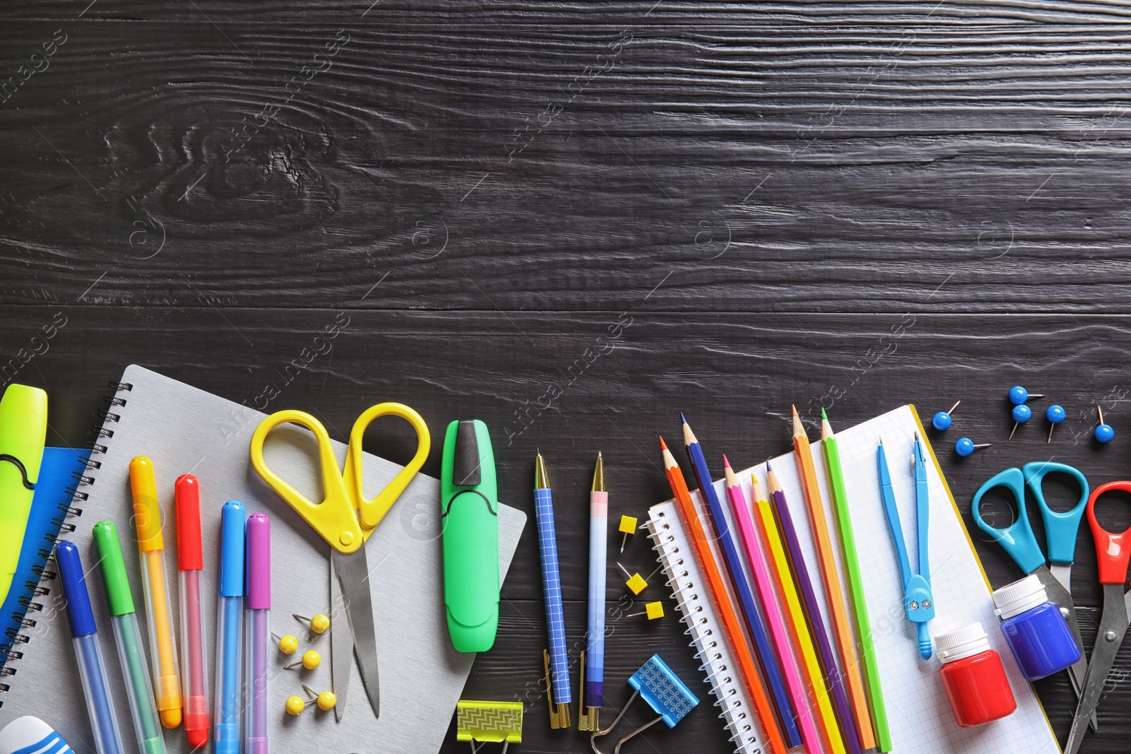 Photo of Different school stationery with space for design on wooden background, flat lay