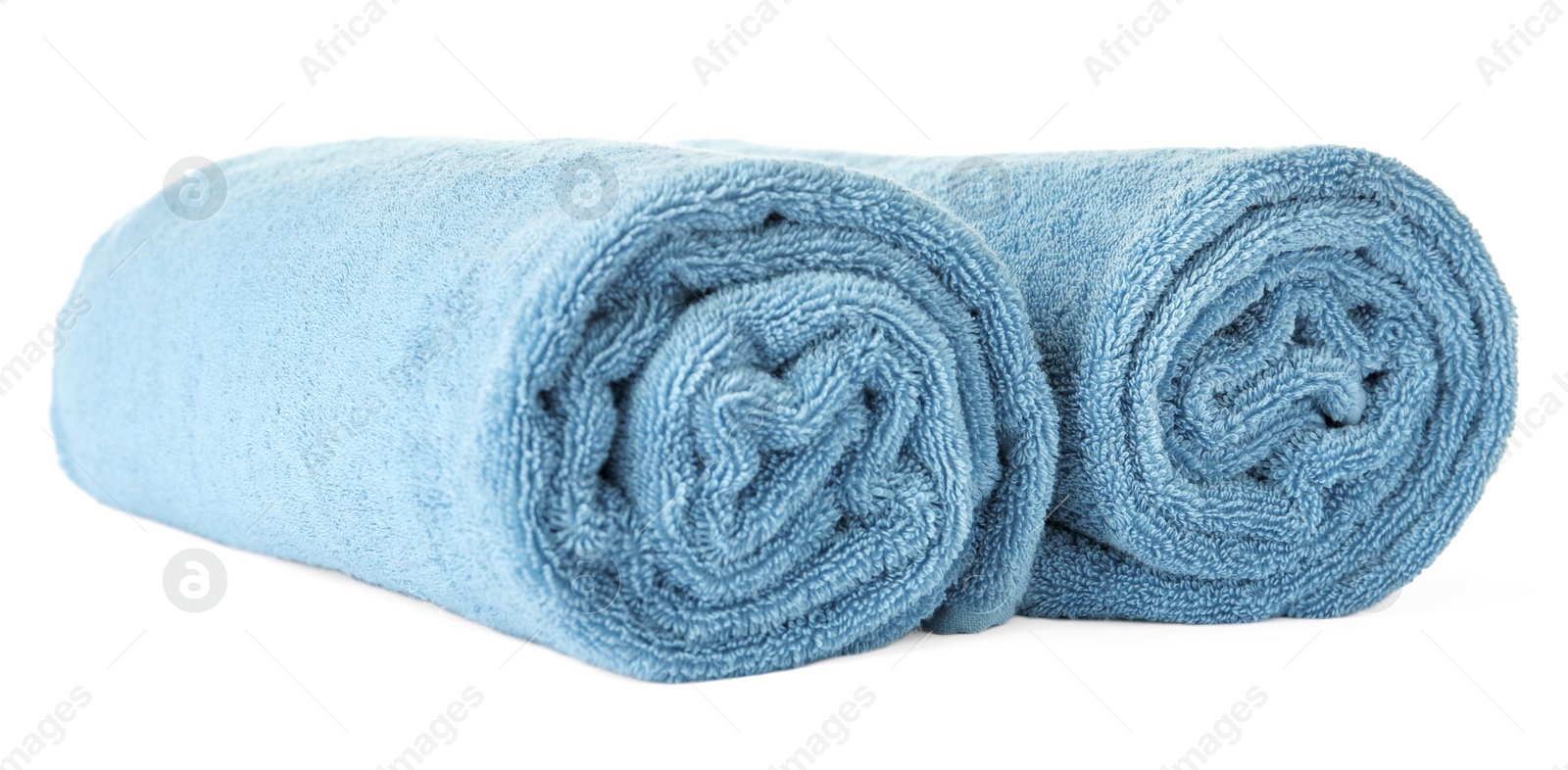 Photo of Rolled clean blue towels on white background