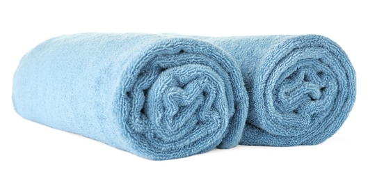 Rolled clean blue towels on white background